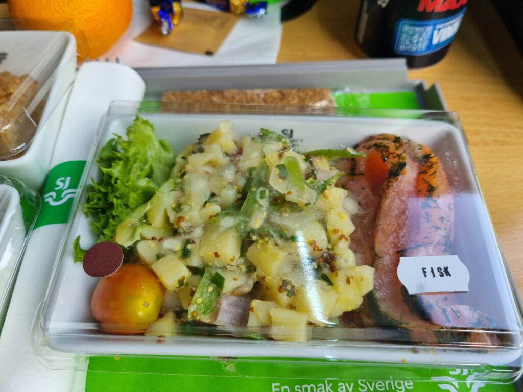 Ännu en tågresa med god mat ombord. Bild på en maträtt serverad ombord på ett svenskt snabbtåg. Potatissallad och gravad lax.