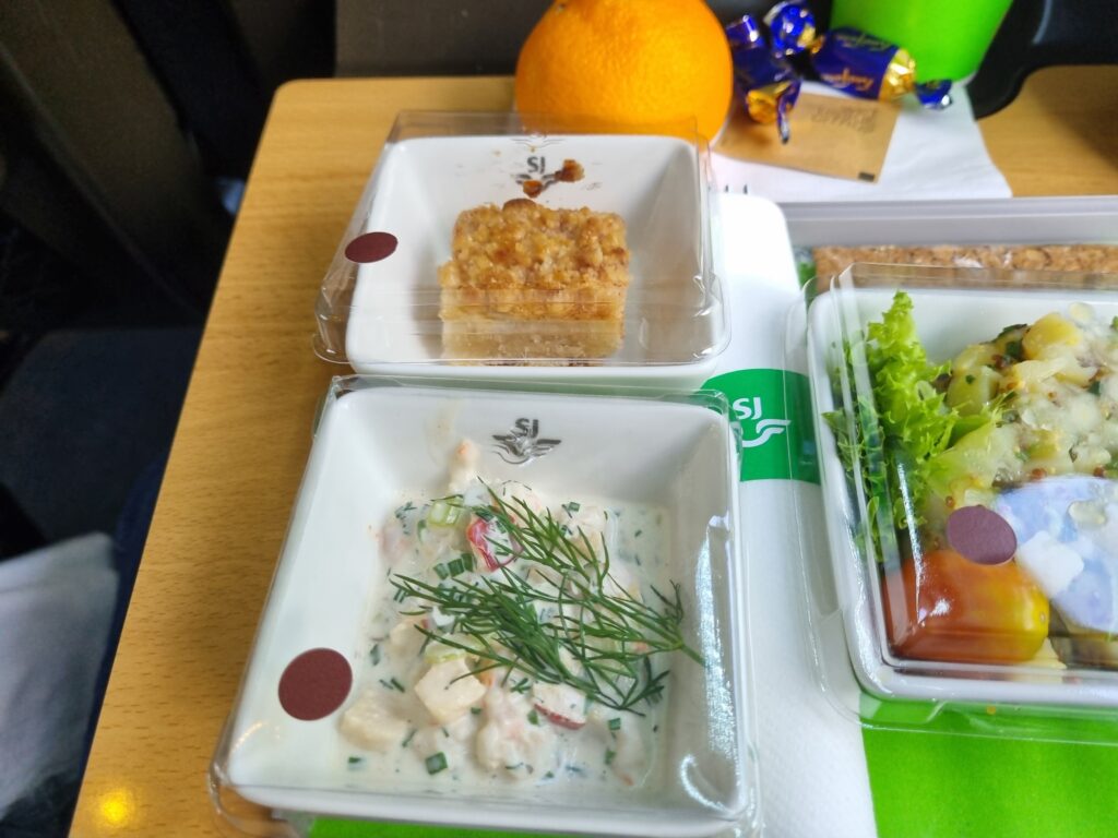 Ännu en tågresa med god mat ombord. Bild på sillsallad och äppelkaka serverad i 1 klass på ett svenskt snabbtåg.